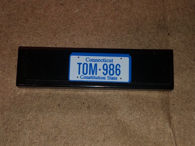 Lego Tile 1 x 4 with 'TOM 986' on Black Background Pattern (Sticker) - Set 10242 / Black