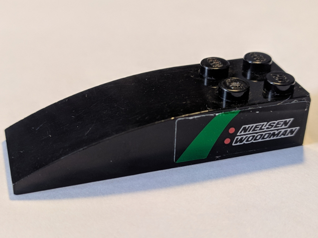 Lego Slope, Curved 6 x 2 with 'NIELSEN WOODMAN' Pattern Model Right Side (Sticker) - Set 8184 / Black