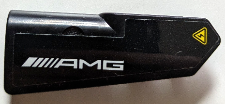 Lego Technic, Panel Fairing #21 Very Small Smooth, Side B with White 'AMG' Logo and Yellow Electricity Warning Triangle Pattern (Sticker) - Set 42165 / Black