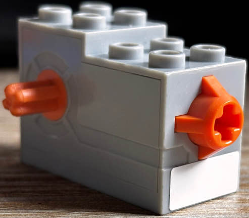 Lego Windup Motor 2 x 4 x 2 1/3 with Orange Axle and Release Button with White Rectangle Pattern (Sticker) - Set 7738 / Light Bluish Gray