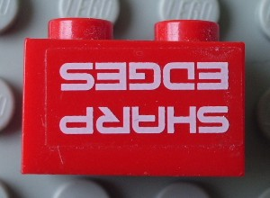 Lego Brick 1 x 2 with 'SHARP EDGES' Upside Down Pattern (Sticker) - Set 7701 / Red
