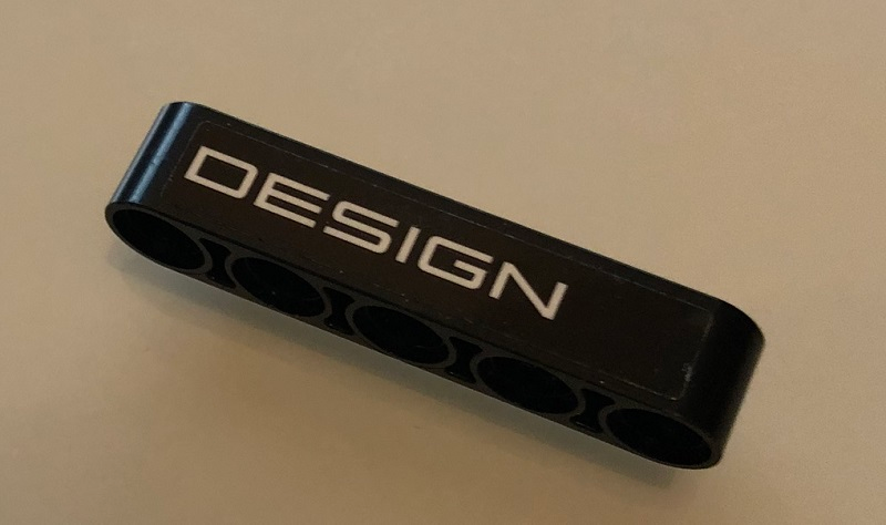 Lego Technic, Liftarm Thick 1 x 5 with White 'DESIGN' on Black Background Pattern (Sticker) - Set 42096 / Black