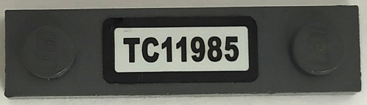 Lego Plate, Modified 1 x 4 with 2 Studs without Groove with 'TC11985' Pattern (Sticker) - Set 76067 / Dark Bluish Gray