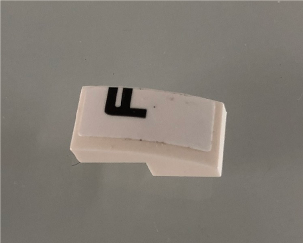 Lego Slope, Curved 2 x 1 x 2/3 with Black Letter F on White Background Pattern Model Left Side (Sticker) - Set 42096