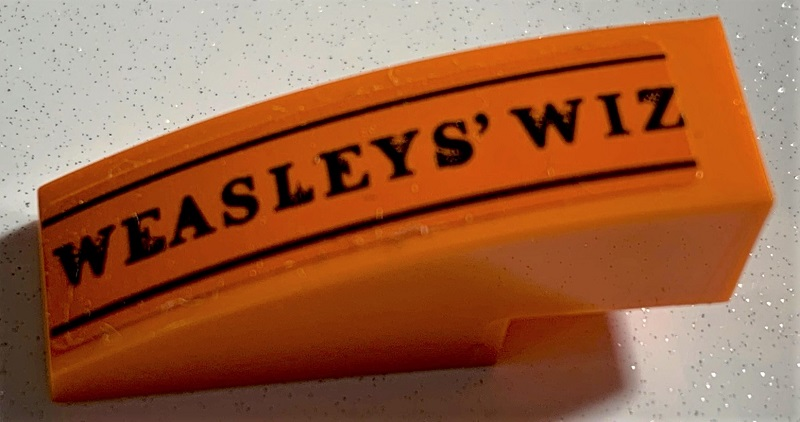 Lego Slope, Curved 3 x 1 with Black 'WEASLEYS' WIZ' and Lines Pattern (Sticker) - Set 75978 / Orange