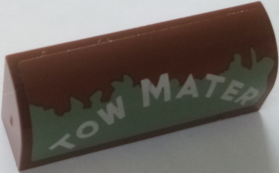Lego Slope, Curved 1 x 4 x 1 1/3 with White 'TOW MATER' on Worn Sand Green Background Pattern Model Left Side (Sticker) - Set 8677