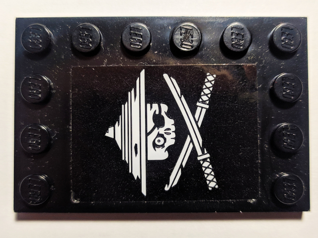 Lego Tile, Modified 4 x 6 with Studs on Edges with White Ninja Skull and Crossed Swords on Black Background Pattern Model Left Side (Sticker) - Set 70605