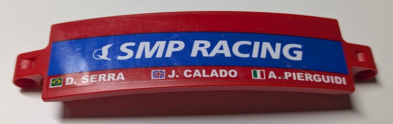 Lego Technic, Panel Curved 3 x 13 with White 'SMP RACING' on Blue Stripe, 'A. PIERGUIDI', 'J. CALADO', 'D. SERRA', Italian, United Kingdom Union Jack and Brazilian Flags Pattern Model Right Side (Sticker) - Set 42125 / Red