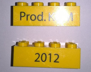 Lego Brick 2 x 4 with Black '2012' and 'Prod. KOM' Pattern on Opposite Sides (Kornmarken Factory Tour) / Yellow