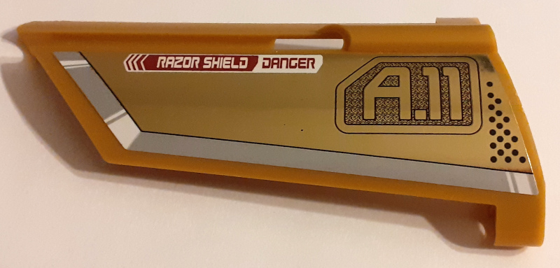Lego Technic, Panel Fairing #21 Large Long, Small Hole, Side B with 'RAZOR SHIELD DANGER' and 'A.11' Pattern (Sticker) - Set 7714 / Pearl Gold