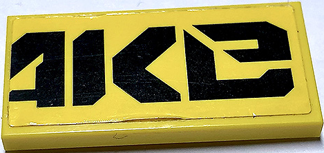 Lego Tile 2 x 4 with Black 'AKe' (QUAKe Right Half) Pattern (Sticker) - Set 70632
