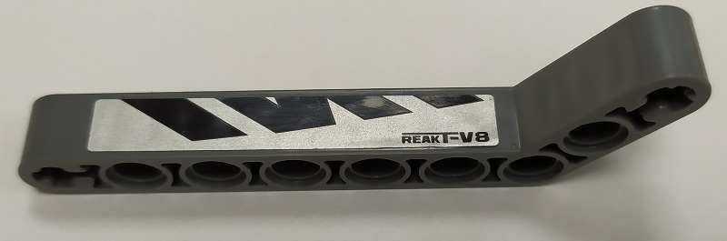Lego Technic, Liftarm, Modified Bent Thick 1 x 9 (7 - 3) with Black 'ReakT-V8' and Polygons on Silver Background Pattern Model Right Side (Sticker) - Set 8863