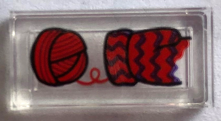 Lego Tile 1 x 2 with Red Yarn and Knitting Pattern (Sticker) - Set 21336 / Trans-Clear